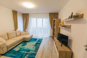 uma sala de estar com um sofá e uma televisão em RentForComfort Apartment Ella em Brasov