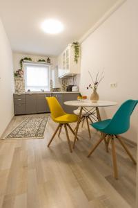 a kitchen with a table and yellow chairs at RentForComfort Apartment Ella in Braşov