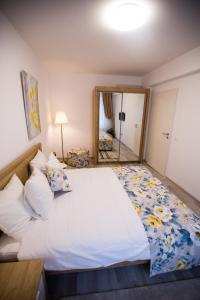 um quarto com uma cama grande e um espelho em RentForComfort Apartment Ella em Brasov