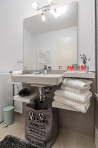 een badkamer met een wastafel, een spiegel en handdoeken bij RentForComfort Apartment Ella 2 in Braşov