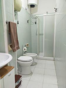 uma casa de banho branca com um WC e um chuveiro em Lu Cori di Sossu em Sorso