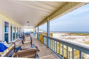 a porch with chairs and the ocean in the background at Beachy Keen in Dauphin Island