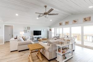 a living room with a couch and a ceiling fan at Beachy Keen in Dauphin Island