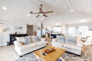 a living room with two couches and a table at Beachy Keen in Dauphin Island
