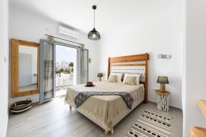 1 dormitorio con cama y ventana grande en Mediterranean Harmony en Náousa