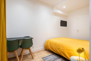 a bedroom with a bed and two chairs at Le Cocon De Paris in Lyon