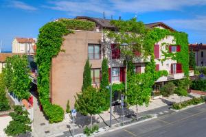 un edificio cubierto de hiedra en una calle de la ciudad en Corso Emanuele Apartments, en San Vincenzo