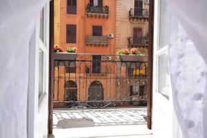 uma varanda aberta com flores num edifício em La Casetta em Palermo