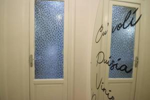 uma porta branca com uma janela num quarto em La Casetta em Palermo