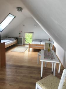 Habitación en el ático con 2 camas y mesa en Siposréti Apartmanház, en Szentgyörgyvár