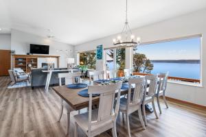 a dining room and living room with a large window at Hook & Cook Beach House in Brinnon