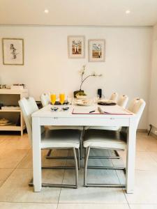 uma mesa de jantar branca com cadeiras e bebidas em Tussen Gracht en SintJan em Den Bosch