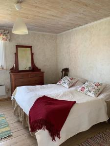 a bedroom with a bed and a dresser and a mirror at Stora Ulvebo in Söderköping