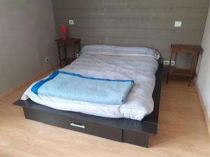 een bed met een zwarte dressoir met een deken erop bij Grande Chambre d'Hôte proche Disneyland et Parc des Félins in Guérard