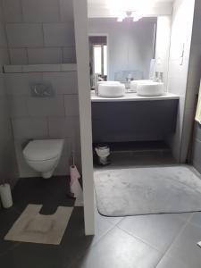 uma casa de banho com 2 lavatórios e um WC em Grande Chambre d'Hôte proche Disneyland et Parc des Félins em Guérard