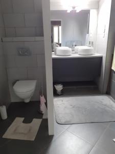 ein Badezimmer mit zwei Waschbecken und einer Toilette in der Unterkunft Grande Chambre d'Hôte proche Disneyland et Parc des Félins in Guérard