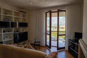 salon z kanapą i przesuwnymi szklanymi drzwiami w obiekcie LIDIA ISEO HOLIDAY w mieście Iseo