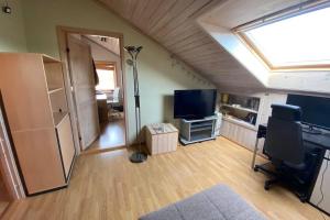 a living room with a skylight and a room with a television at Marikollen, spacious appartment with sunny veranda in Kristiansand