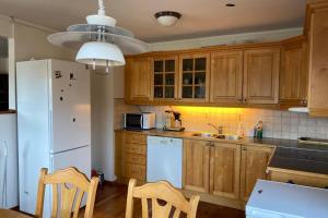 a kitchen with wooden cabinets and a white refrigerator at Marikollen, spacious appartment with sunny veranda in Kristiansand