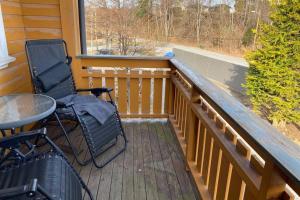 a porch with two chairs and a table and a window at Marikollen, spacious appartment with sunny veranda in Kristiansand