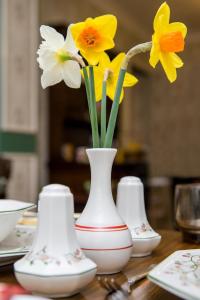 um grupo de vasos com flores sobre uma mesa em All Seasons Gatwick Guest House & Parking em Horley