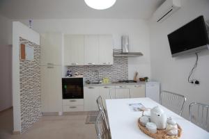 eine Küche mit einem weißen Tisch und einer weißen Arbeitsplatte in der Unterkunft Villa Cecita in Sellia Marina + 14 Fotos