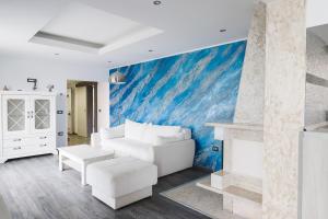 a living room with a white couch and a blue wall at Apartments Villa Sofia in Crveni Vrh