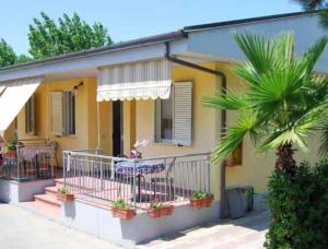 a yellow house with a balcony and a palm tree at JuliaMare Village in Giulianova