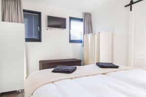 a bedroom with a bed with two towels on it at Vrijstaande vakantiewoning Petite Renard in Zoutelande