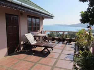 une terrasse avec une table et une chaise sur une maison dans l'établissement Flower Paradise Bungalows & Swiss Restaurant Roestiland, à Lamai