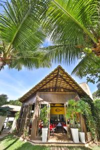 a small house with a palm tree at Brasil Tropical Village in Pipa