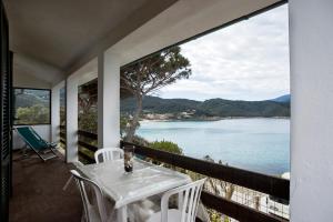 un tavolo e sedie su un balcone con vista sull'acqua di Casa Sabrina a Portoferraio