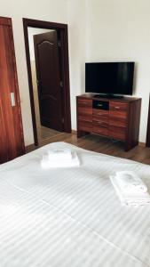 a bedroom with a bed and a flat screen tv at Pensiunea Simi in Moisei