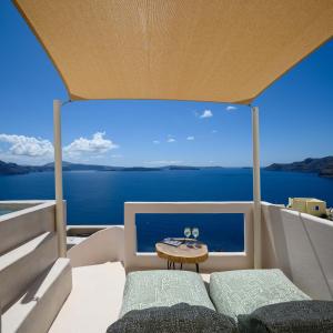 een uitzicht vanaf de achterkant van een boot met een tafel bij Canvas Suites in Oia