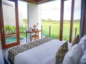 Schlafzimmer mit einem Bett und Blick auf ein Feld in der Unterkunft Villa Omkara Ubud in Ubud