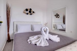 2 cigni seduti su un letto in una camera da letto di Blue Soul Luxury Villa a Éxo Goniá