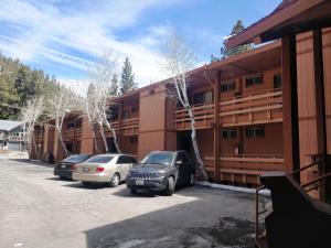 Dos coches estacionados en un estacionamiento frente a un edificio. en Ventura Grand Inn, en Mammoth Lakes 35 fotos más