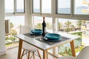 ein Esszimmer mit einem Tisch und einer Flasche Wein in der Unterkunft Montevideo Beach - Apartamento con vistas al mar recién renovado in Algarrobo-Costa