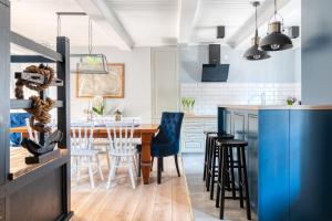 cocina con mesa de madera y sillas azules en Dom Wakacyjny Fiszeria, en Hel