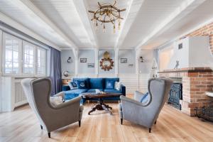 a living room with a blue couch and chairs at Dom Wakacyjny Fiszeria in Hel