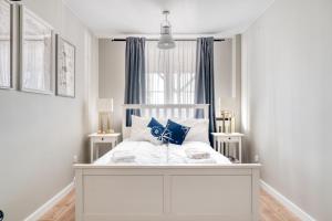 赫爾的住宿－Dom Wakacyjny Fiszeria，卧室内的白色床和蓝色枕头
