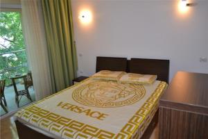 a bedroom with a bed with a yellow and white blanket at apartament PIANO in Mamaia +16 photos