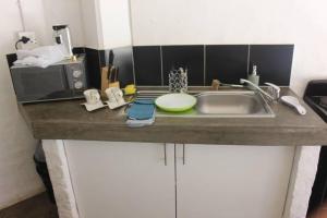 W kuchni znajduje się umywalka i kuchenka mikrofalowa. w obiekcie Relax In Maboneng w mieście Johannesburg