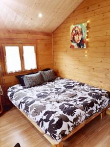 ein Schlafzimmer mit einem Bett in einer Holzhütte in der Unterkunft Chalet sur pilotis avec piscine privée in Lucéram