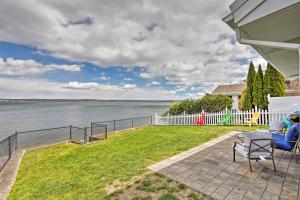 a house with a patio with a view of the water at Waterfront Portsmouth Cottage 8 Mi From Newport! in Portsmouth