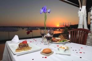 a table with a plate of food and a purple flower at Hostal la Savina in La Savina