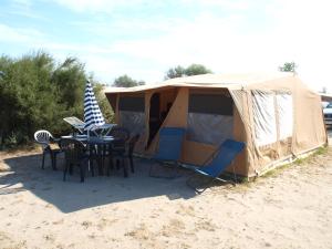 Oh! Campings - La Tamarissière Agde في آجد: خيمة امامها طاولة وكراسي