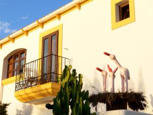 a building with a balcony with flamingos on it at Hostal la Savina in La Savina