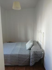 um quarto com uma cama num quarto branco em Casas Rurales Montejaque Pinos em Montejaque