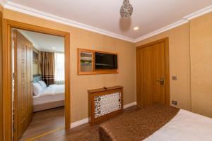 a bedroom with a bed and a tv and a mirror at Golden Sand Hotel in Istanbul